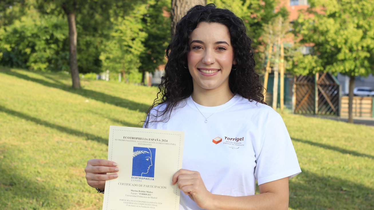 Marina posa con el diploma de participación en Ecotrophelia en el parque de Nicolás Fuster.