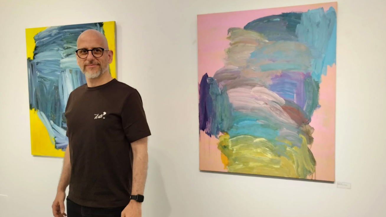 Juan José Molero con dos cuadros de la exposición.